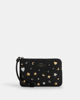 محفظة بسوار معصم وسحّاب جانبي مزينة بتفاصيل معدنية